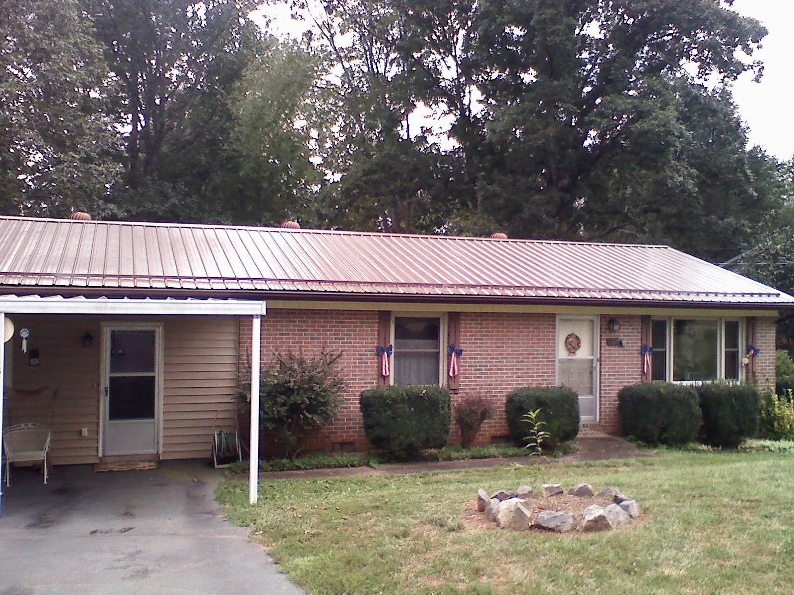Bronze metal roof and carport on a brick ranch home — Roof Repair work by our crew in Niota